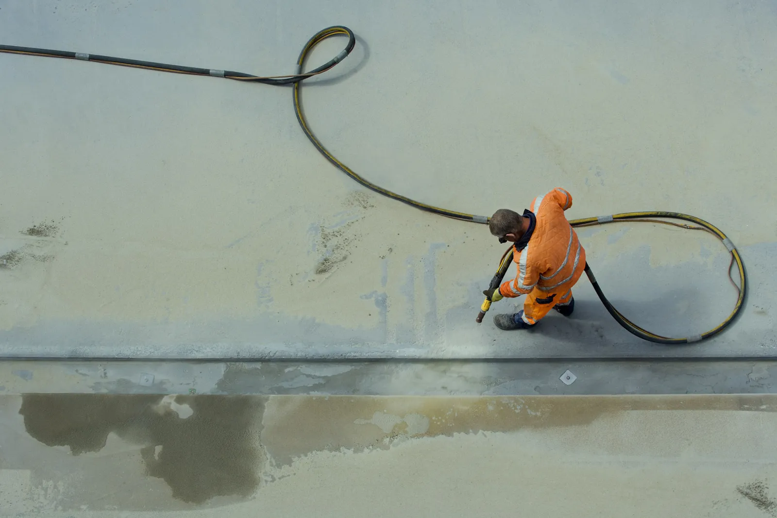 Concrete surface being sandblasted clean before a new coating